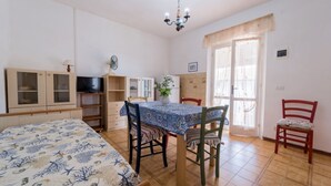 A room with a bed, a dining table with chairs, a TV, and a window with curtains. - APPARTAMENTI CAMPO AL PERO - CAMPO AL PERO - BILO 2 (Rio dell'Elba)