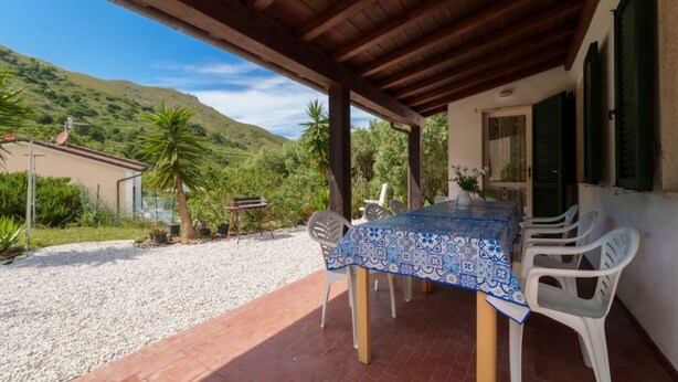 A covered outdoor dining area with a table set for four, surrounded by white plastic chairs. - APPARTAMENTI CAMPO AL PERO - CAMPO AL PERO - TRILO 3 (Rio dell'Elba)