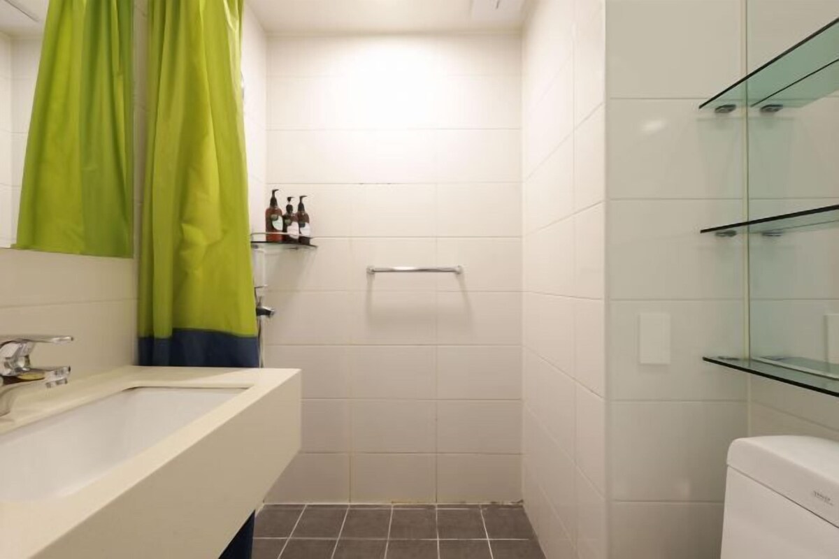 A bathroom with a white sink, a glass shower enclosure, and a toilet.