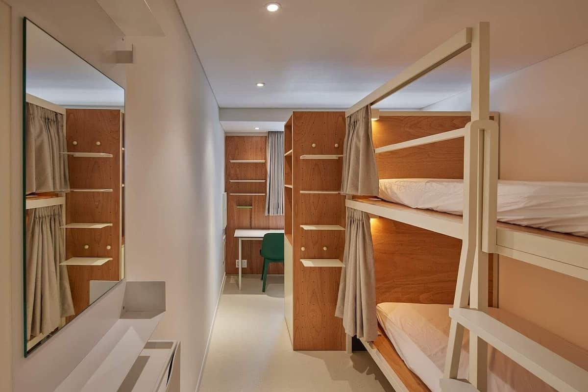 A bedroom with bunk beds, a desk, and a chair.