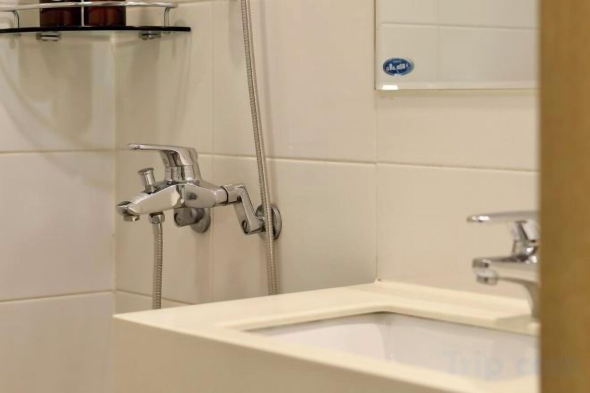 A bathroom with a shower, a sink, and a mirror.