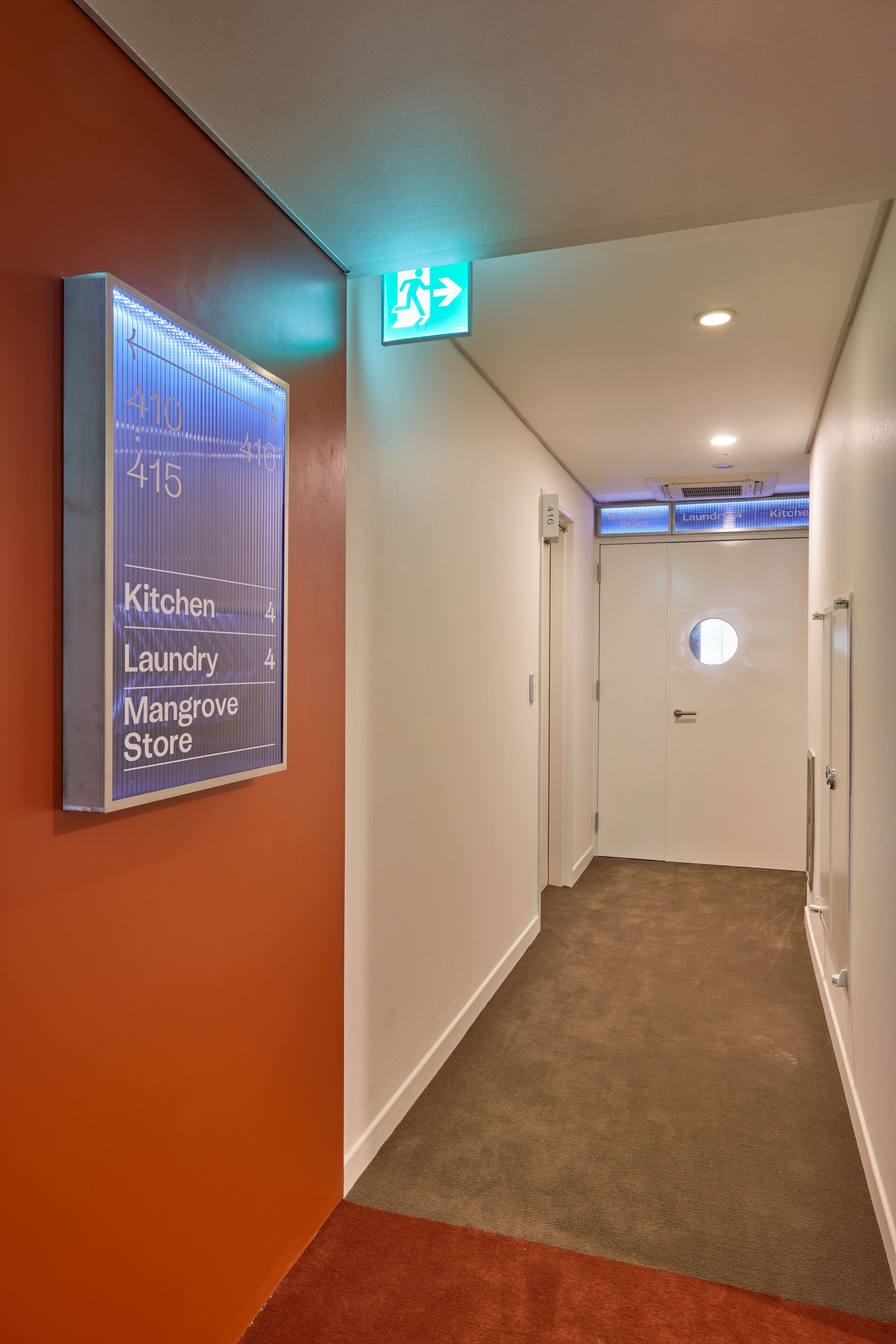 A hallway with a sign indicating the locations of the kitchen, laundry, and mangrove store.