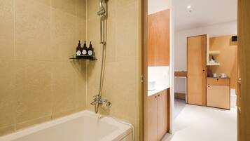 A modern bathroom with a bathtub, a shower, and wooden cabinets.