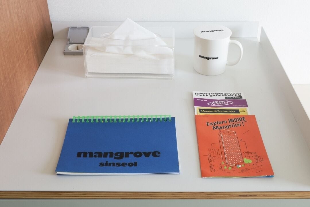 Een bureau met een notitieboek, een beker, een zakdoos en een folder.