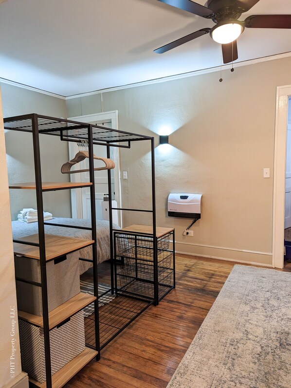A room with a bunk bed, a ceiling fan, a wall-mounted heater, and a wooden floor. - Contemporary Style (Florence)