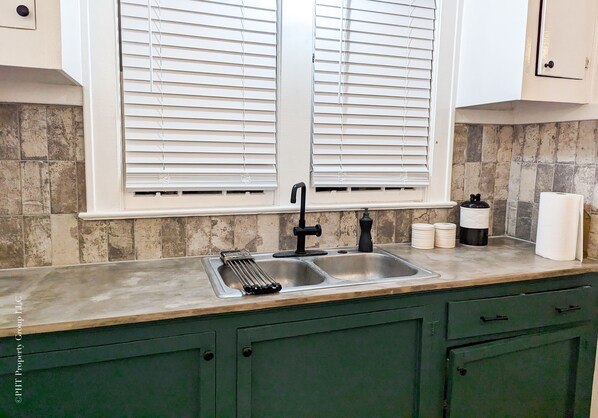 A kitchen with a double sink, a faucet, a spice rack, and a window with blinds. - Contemporary Style (Florence)