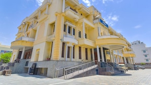 A multi-story building with balconies, a staircase, and a sign indicating it is a hotel.