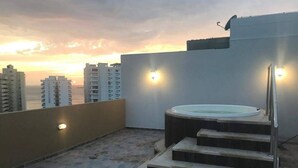 A rooftop terrace with a hot tub, stairs, and city views at sunset. - Magico Apt 1401 Bello Horizonte (Santa Marta)
