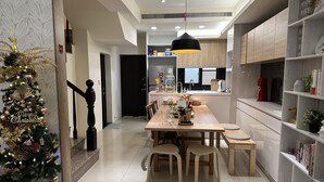 Una cocina moderna con comedor, un árbol de Navidad y un robot aspirador.