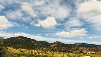A mountainous landscape with a clear sky and scattered clouds.