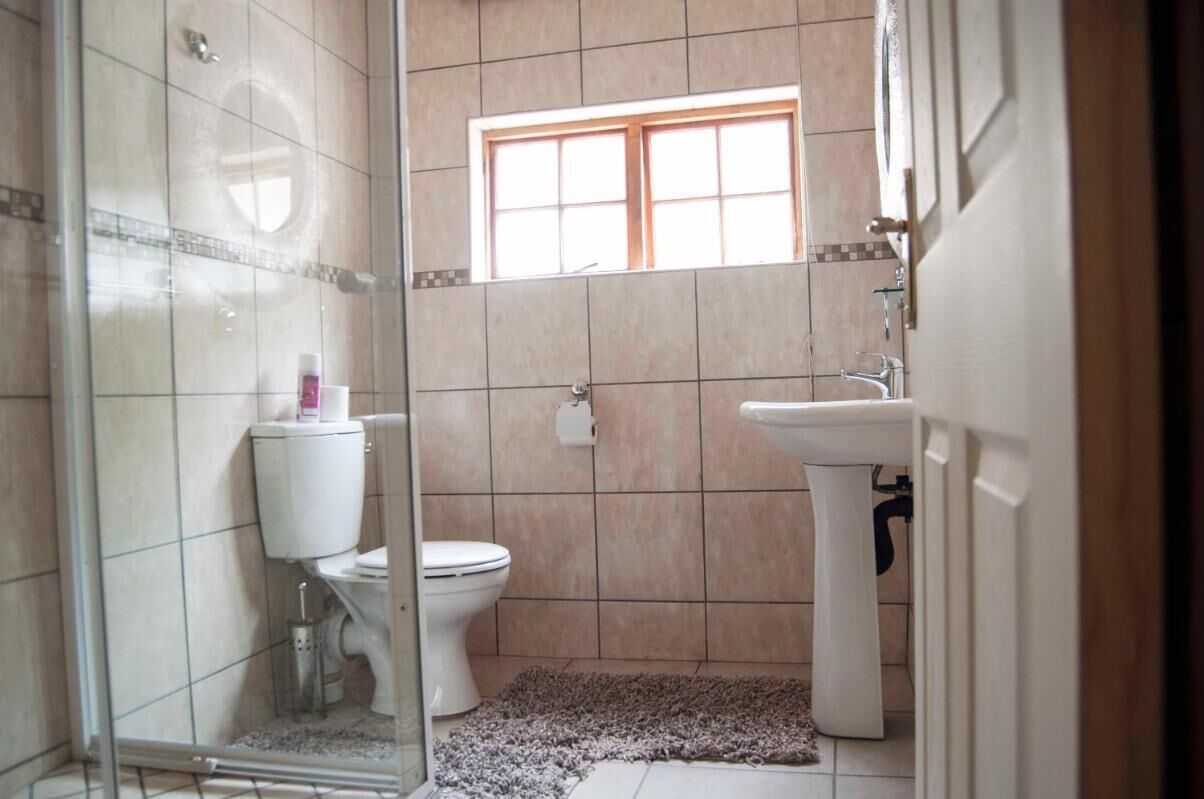 Un bagno con il water, un lavandino e una finestra.