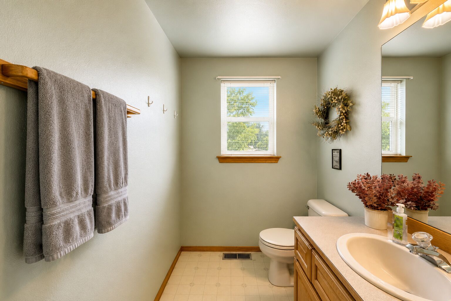 A bathroom with a toilet, sink, and towel rack.