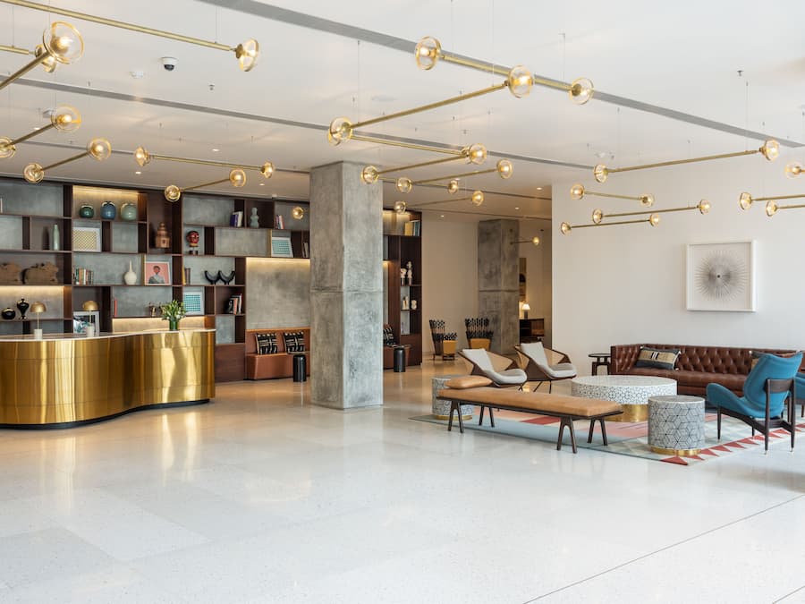 A modern lobby with a reception desk, seating area, and decorative lighting.