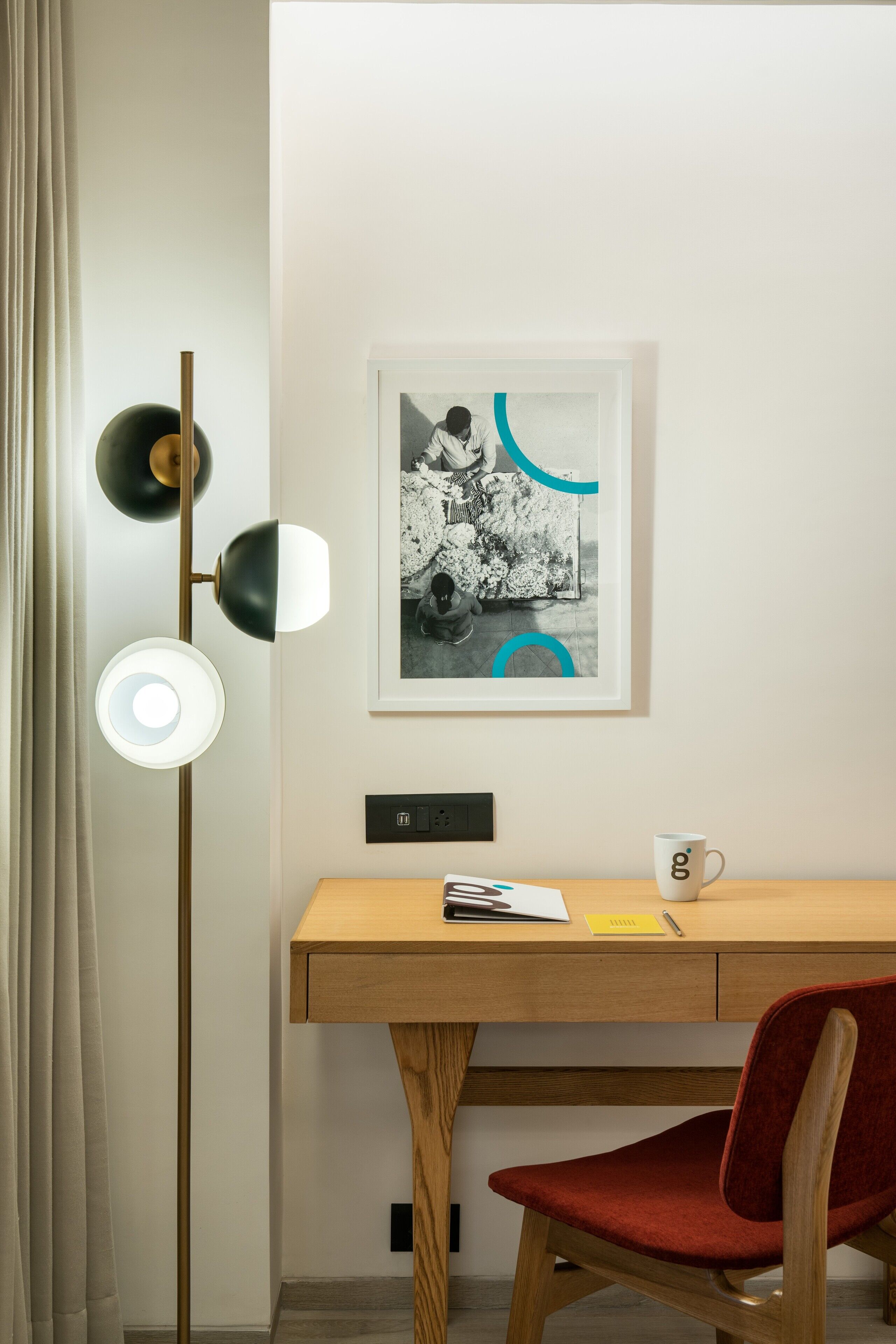 A modern office space with a desk, chair, and a floor lamp.