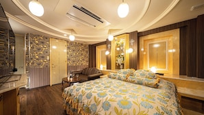 Une chambre d’hôtel avec un grand lit, un bureau, une chaise et un miroir.