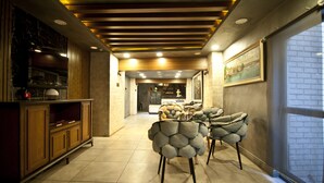 A modern interior with a wooden ceiling, a kitchen area, and a seating area with unique chairs. - Nova City Hotel (Istanbul)