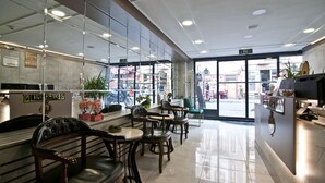 A modern interior with a reception desk, seating area, and large windows. - Nova City Hotel (Istanbul)