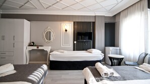 A hotel room with two beds, a desk, a chair, a TV, and a large mirror. - Nova City Hotel (Istanbul)