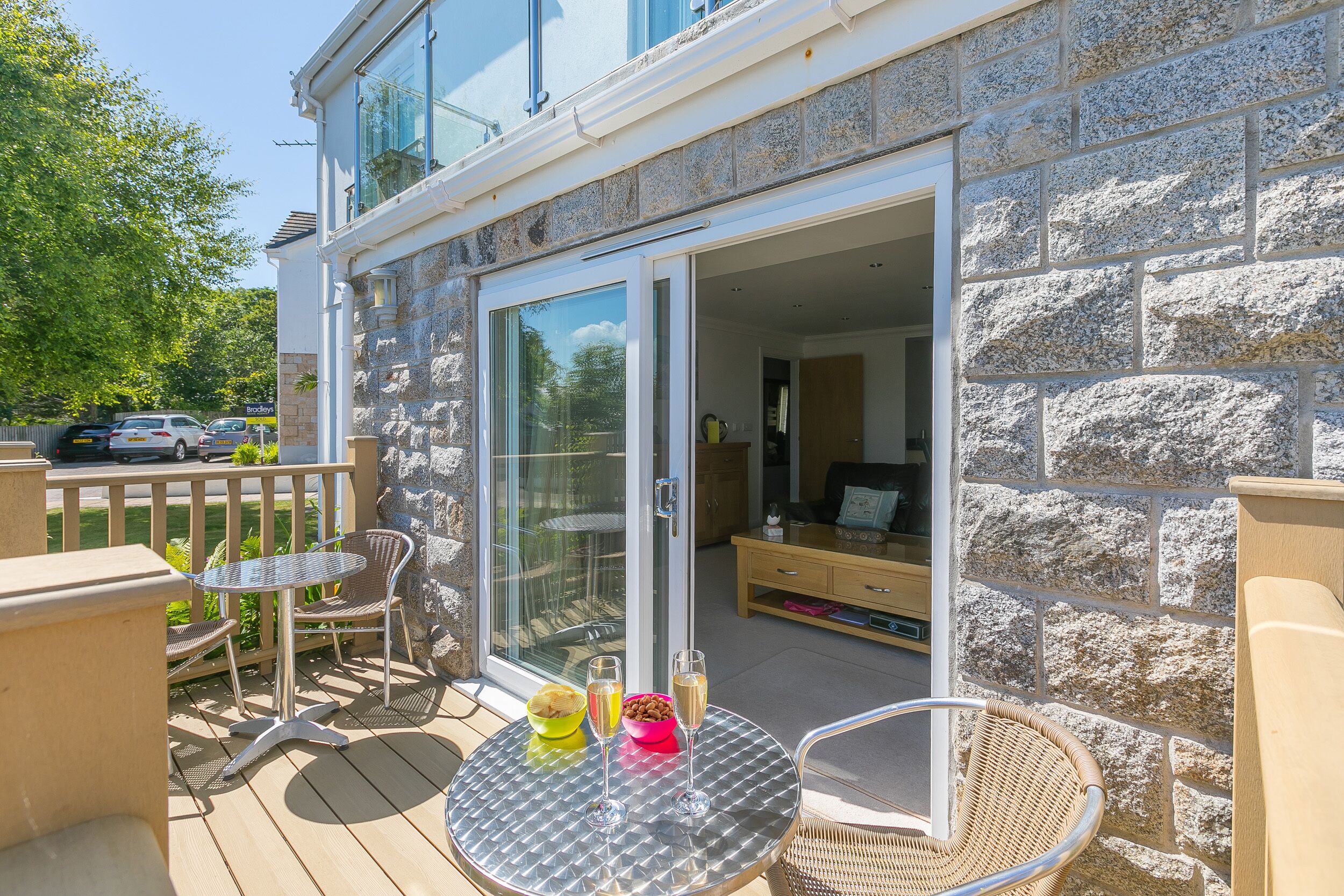 A patio with a table, chairs, and a glass door leading to an interior space.