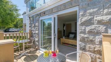 A patio with a table, chairs, and a glass door leading to an interior space.
