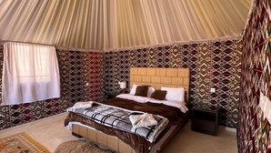 Um quarto acolhedor com cama, tapete e paredes estampadas.
