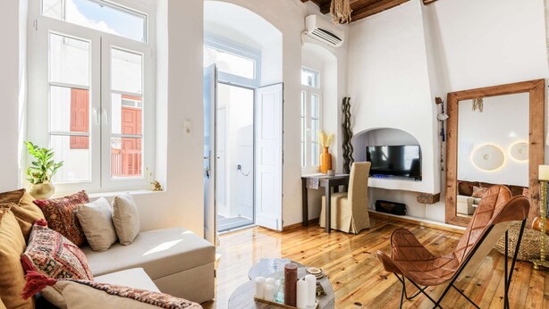 Un salon moderne avec un canapé, un téléviseur et un plancher en bois.