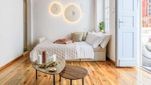 Une chambre à coucher avec un lit, une table de chevet et une vue sur l’extérieur.