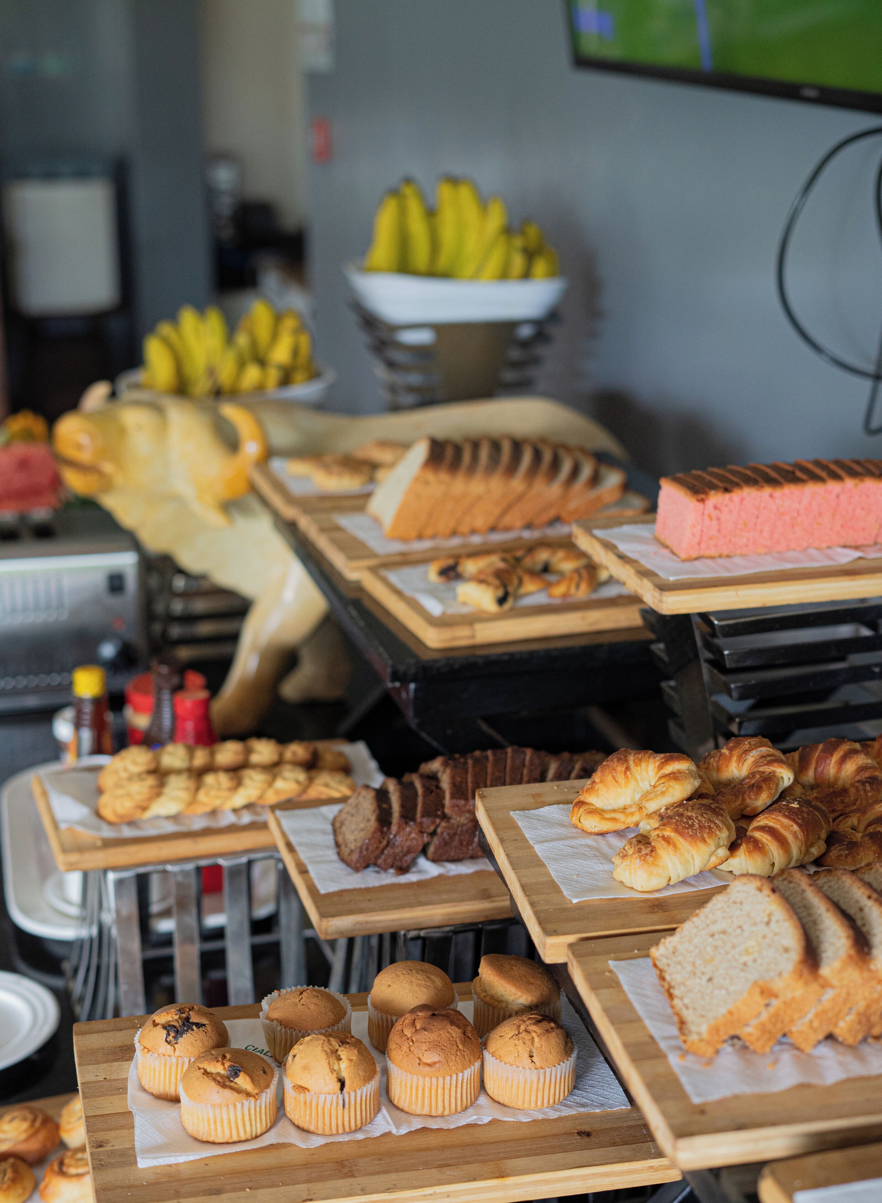 Una vetrina di pasticceria con diversi prodotti da forno come muffin, croissant e pane.
