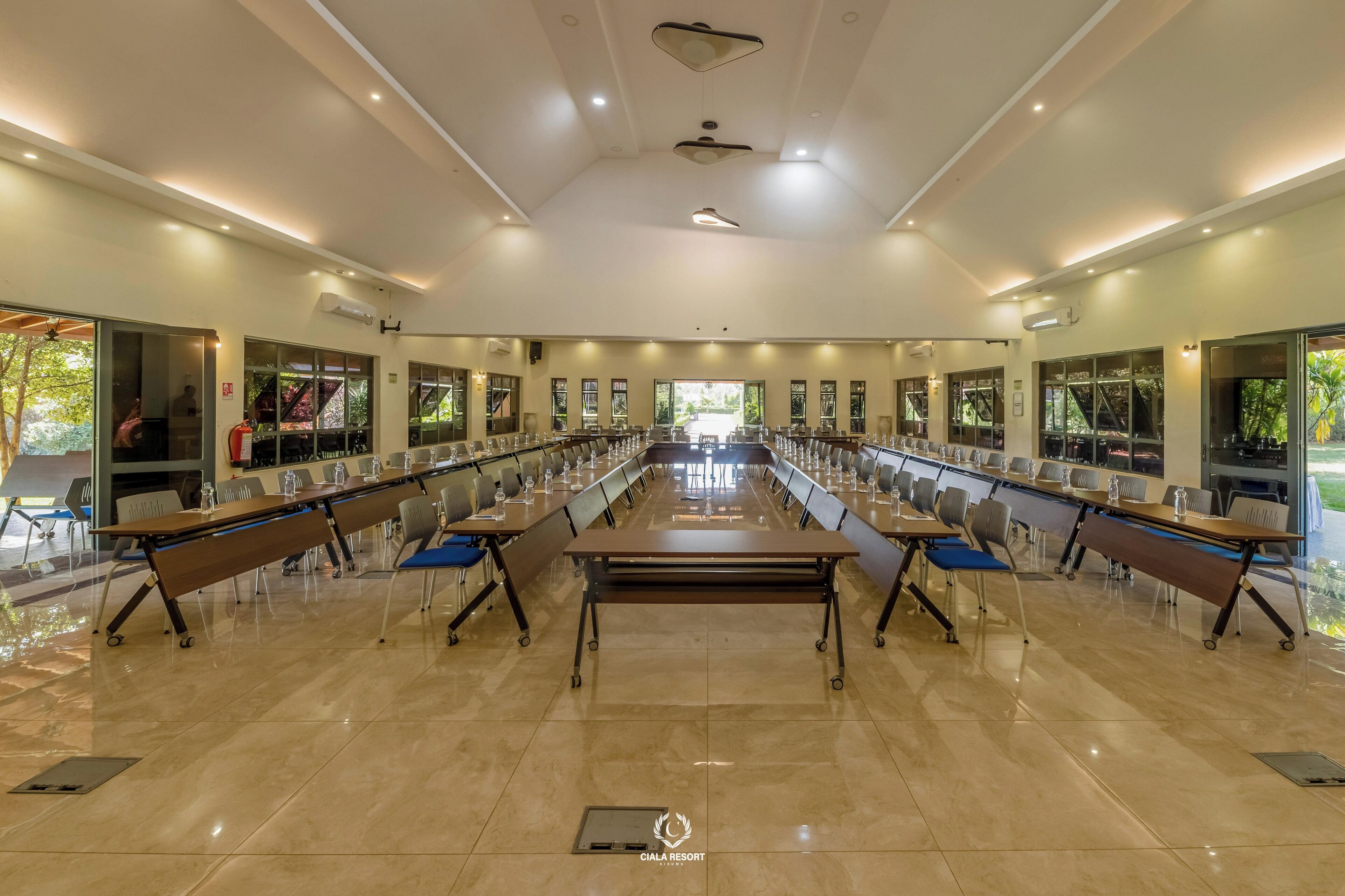 A spacious conference room with a long table, chairs, and a ceiling fan.