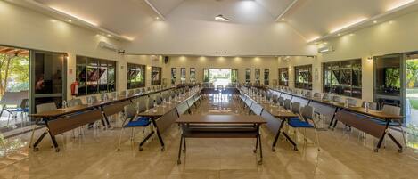 A spacious conference room with a long table, chairs, and a ceiling fan.
