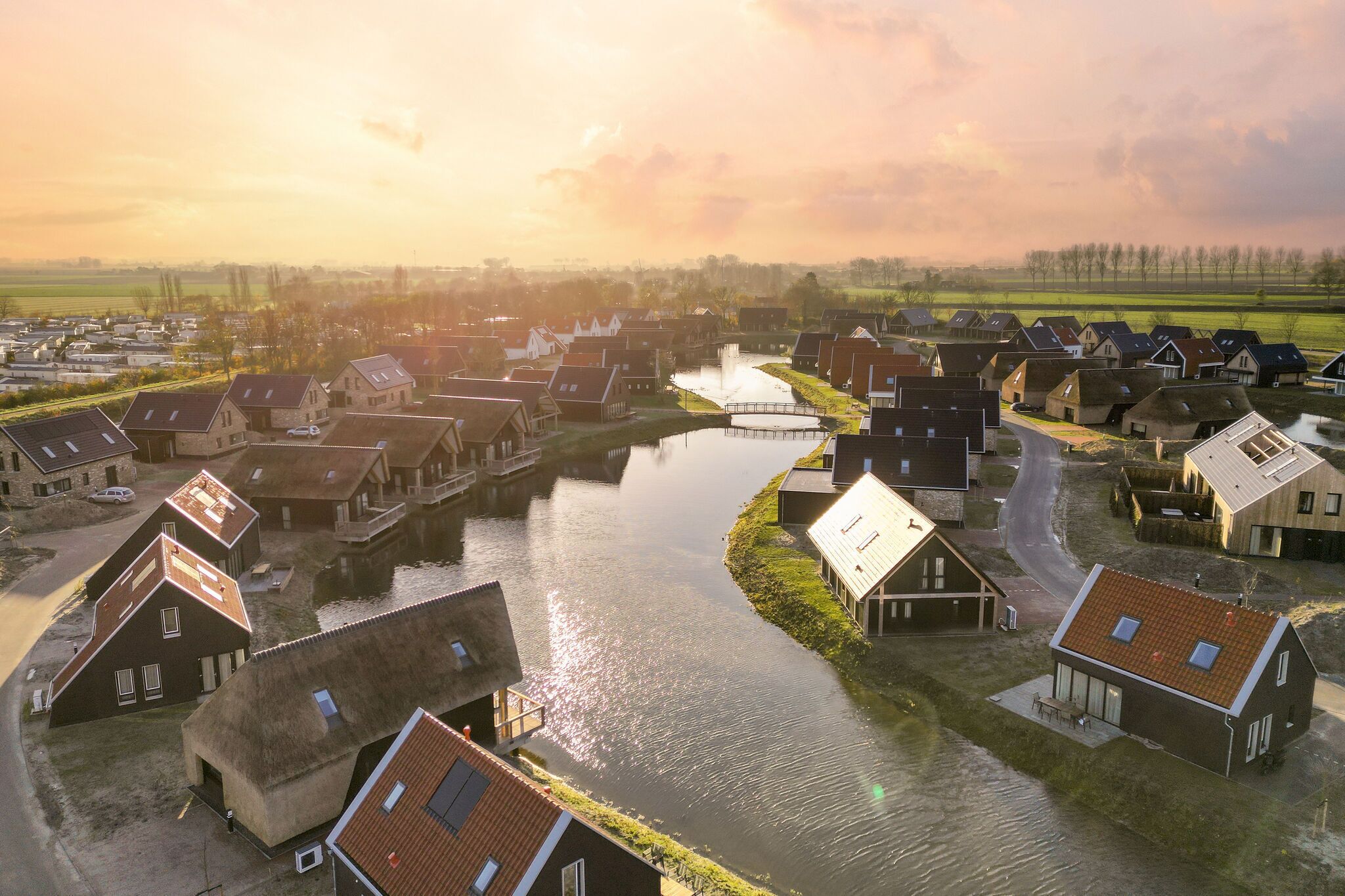 A riverside village with traditional houses, a canal, and a bridge.