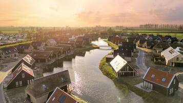 A riverside village with traditional houses, a canal, and a bridge.