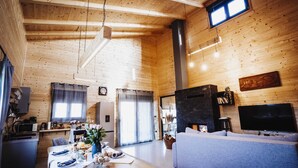 A cozy cabin interior with a dining area, living room, and a fireplace.