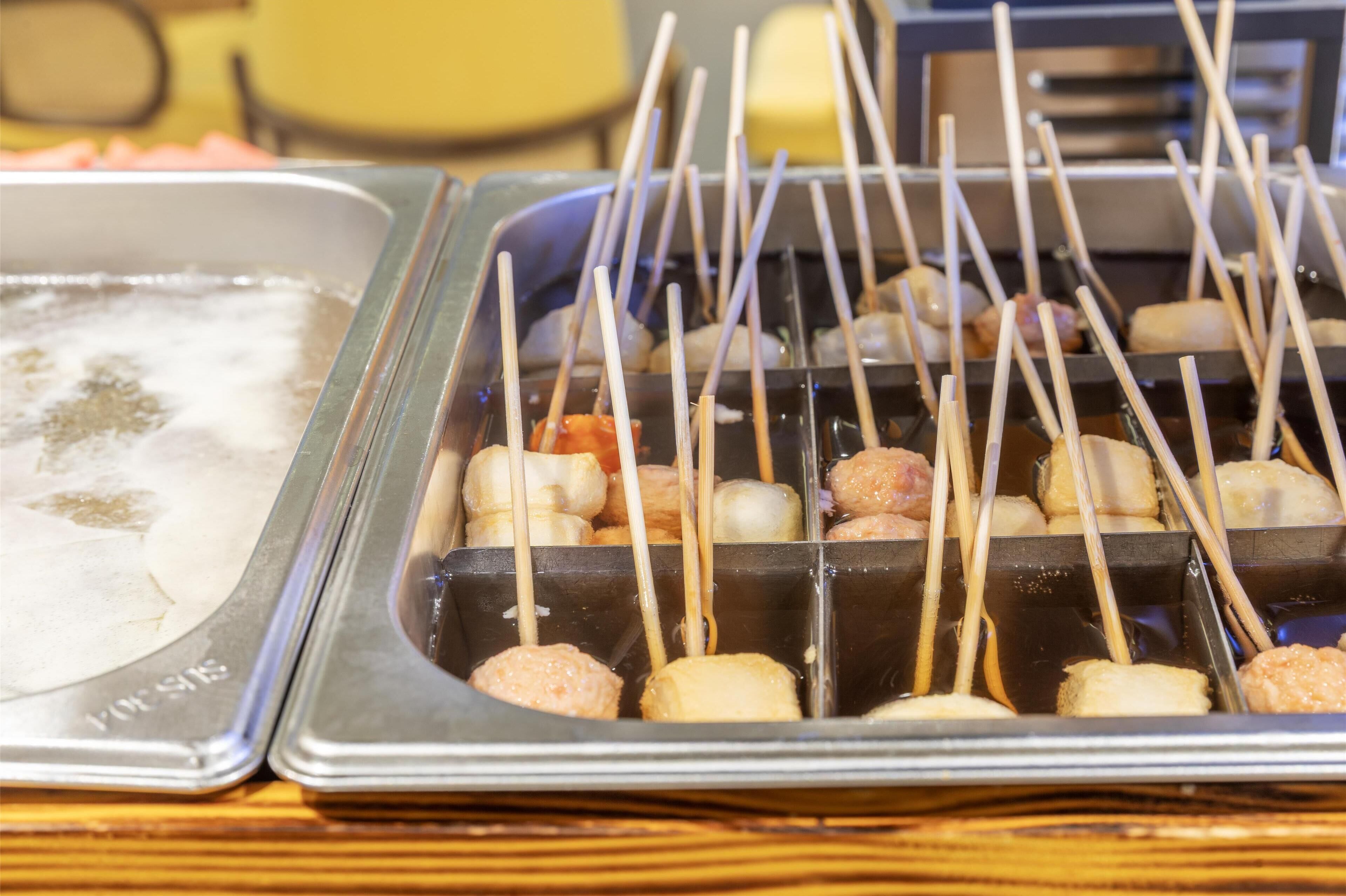 Un bufé con comida ensartada y una bandeja de helado.