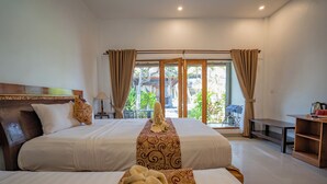 A hotel room with two beds, a wooden headboard, a desk with a chair, and a view of the outdoors through large windows. - Bali Menjangan Boutique Villas (Pemuteran)