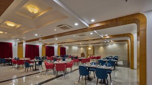 A spacious dining area with multiple tables and chairs, a polished floor, and a modern ceiling design. - Golden Tulip Tirupati (Tirupati)
