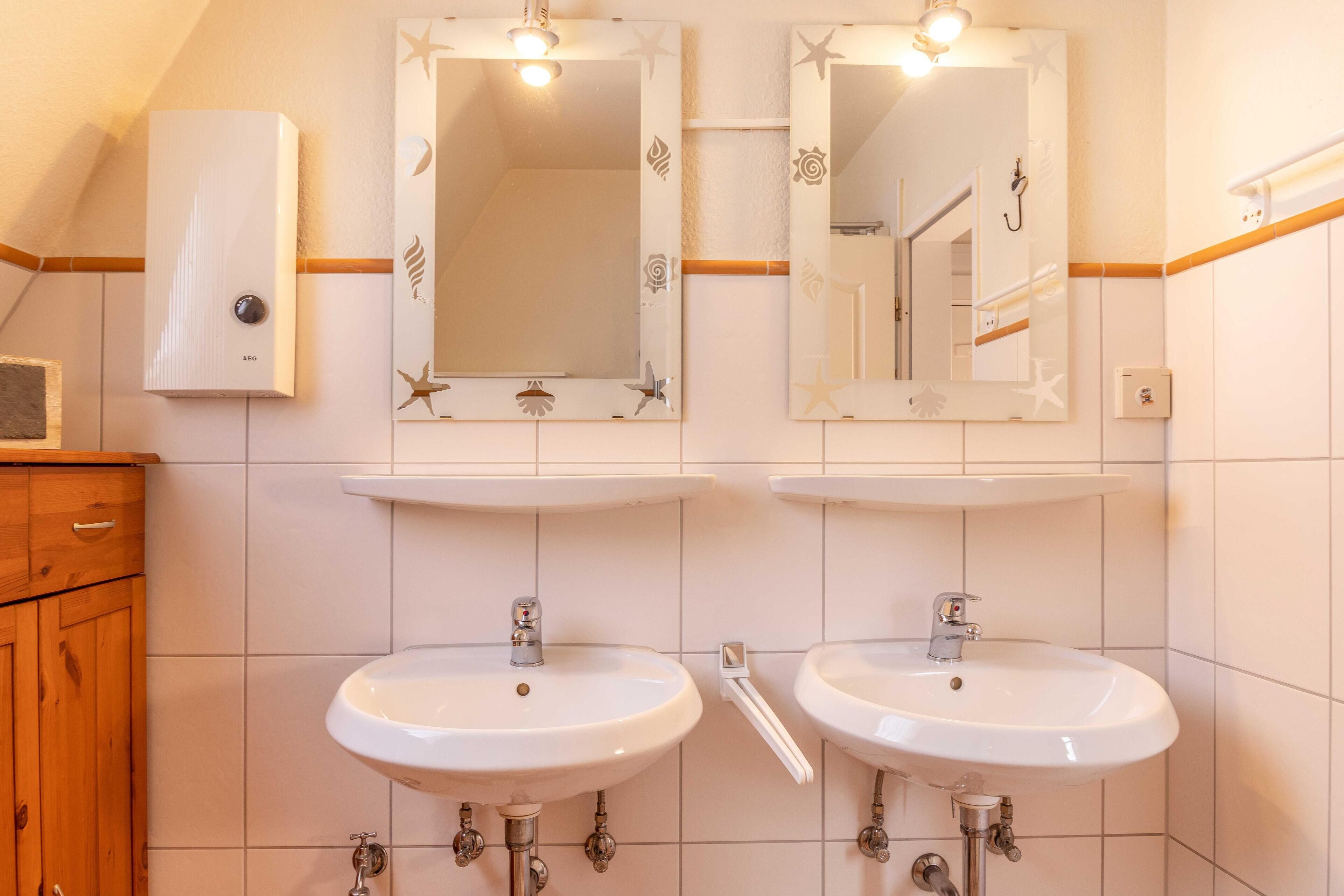 A bathroom with two sinks, a mirror, and a towel rack.