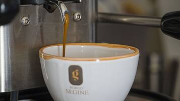 Una taza de café con un logotipo sobre una superficie metálica.
