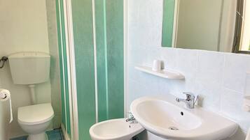 Un bagno con WC, bidet, lavandino e cabina doccia.