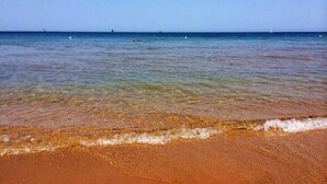 Een strand met helder ondiep water en een zandstrand.
