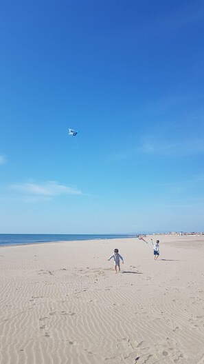 A sandy beach with footprints and a clear blue sky. - House 5 minutes from the beach, shared swimming pool in the residence (Narbonne)