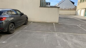 Een parkeerplaats met een BMW auto geparkeerd bij een gebouw.
