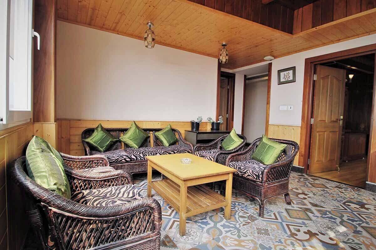 A cozy room with wicker furniture, a wooden ceiling, and patterned floor tiles.