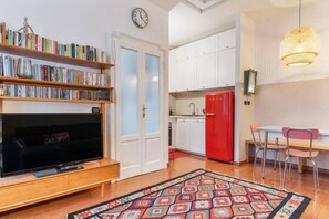 A living room with a TV, bookshelf, and a patterned rug.