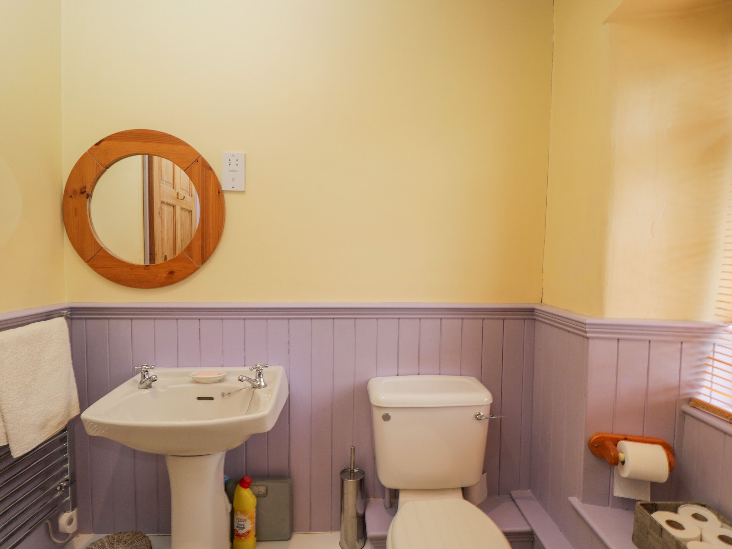 A bathroom with a sink, toilet, and mirror.