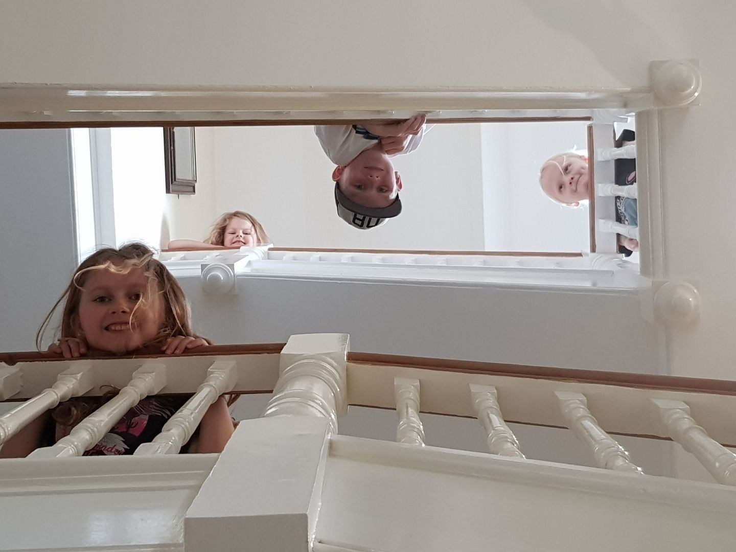 Une chambre avec un berceau blanc, une fenêtre donnant sur un beau paysage, et la tête d’un enfant qui dépasse du bord du berceau.