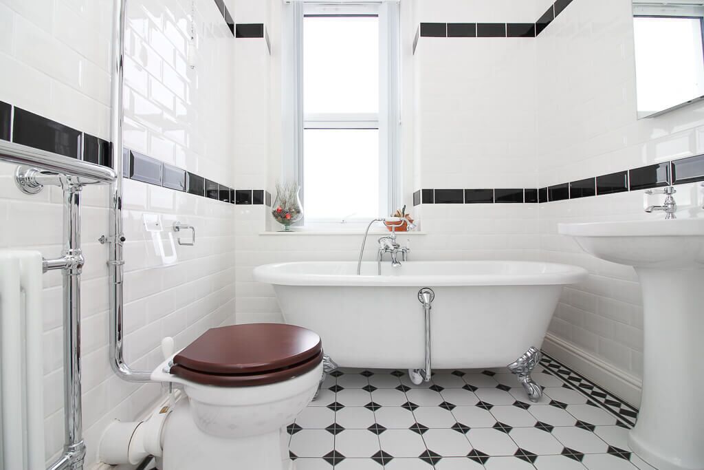 Un baño con inodoro blanco, bañera y lavamanos.