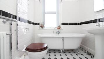 Un baño con inodoro blanco, bañera y lavamanos.