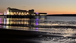A waterfront building with multiple levels and a pier extending into the water. - The Beach House Luxury Rooms (Weston-super-Mare)