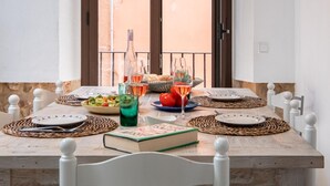 A dining table set with plates, cutlery, a book, and drinks. - Charming Fisherman's House, 150m from Beach, A/C, WiFi, 3 Bedrooms, Central Palamós (Palamós)
